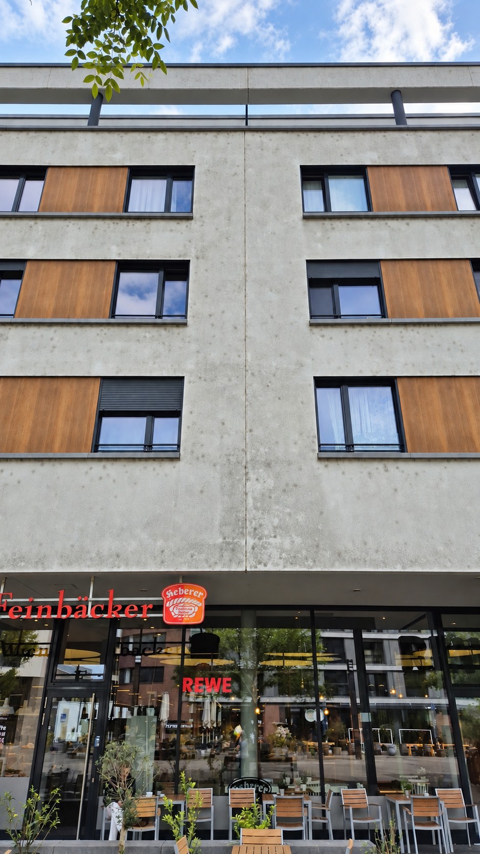 Stark verschmutzte Fassade über Bäckerei und Außenterrasse