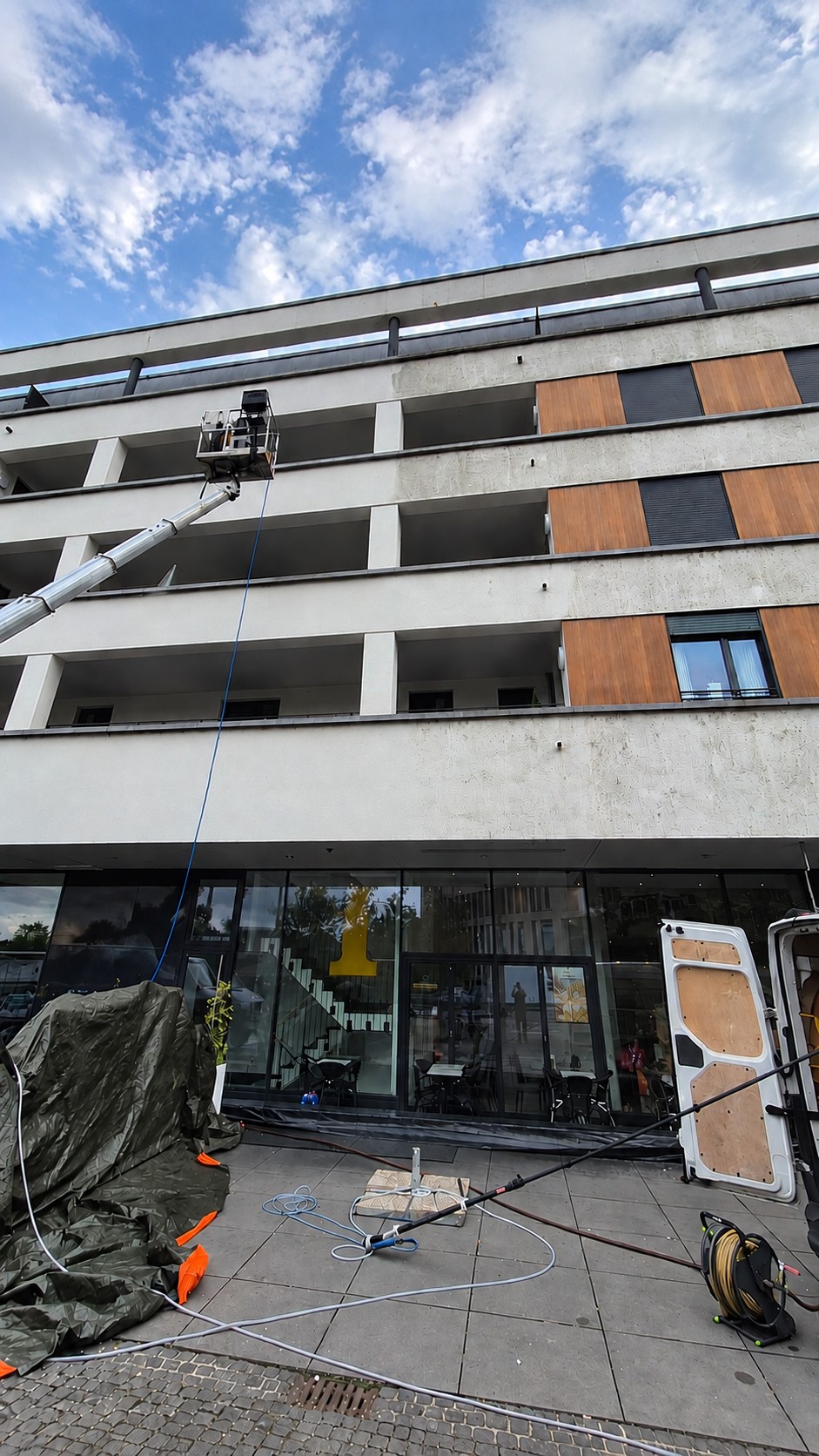Die Außengastronomie liegt unter Folie, darüber arbeitet die Hebebühne an der Fassade