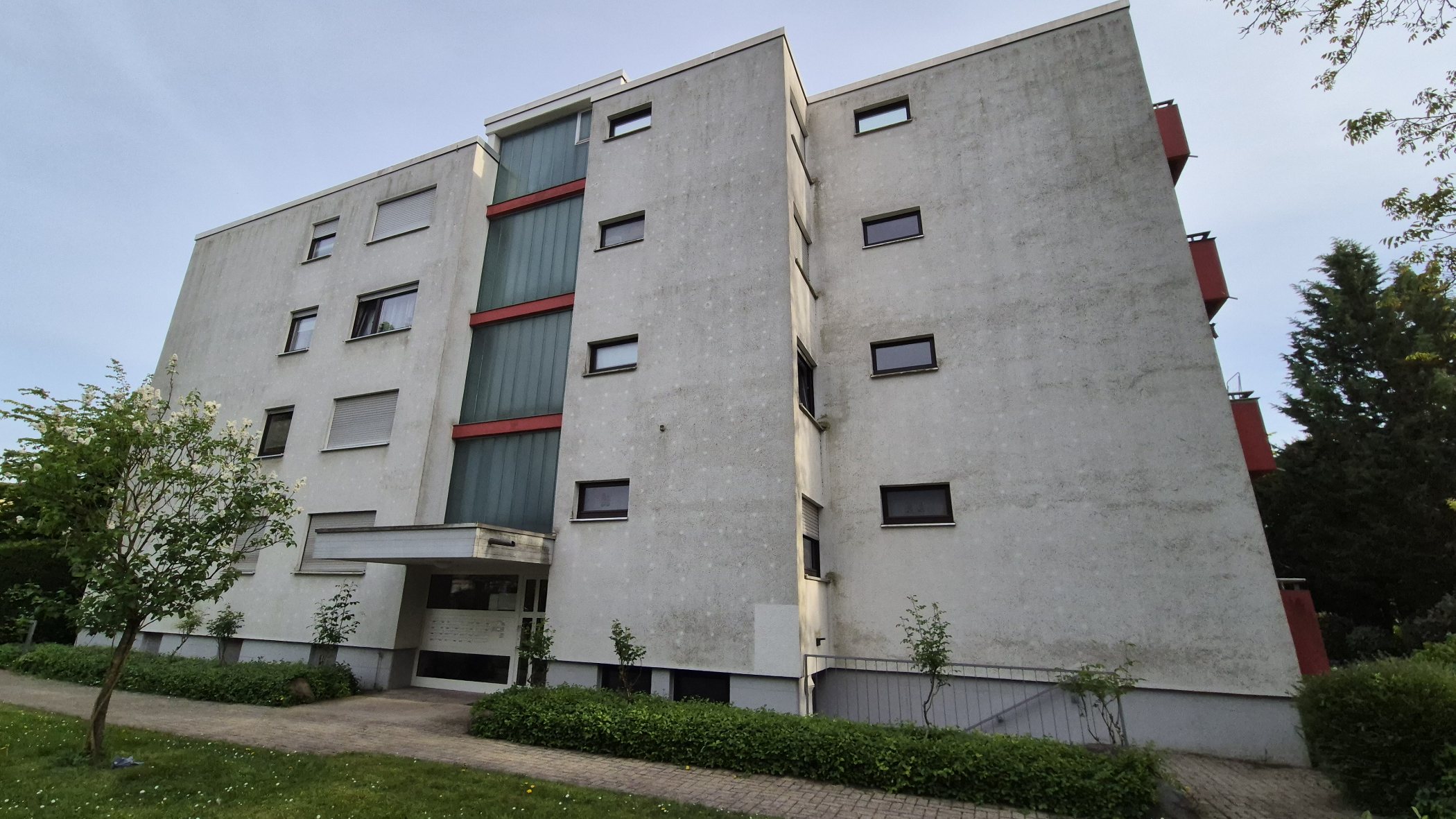 Vierstöckige Wohnanlage mit grau verschmutzter Fassade vor der Reinigung
